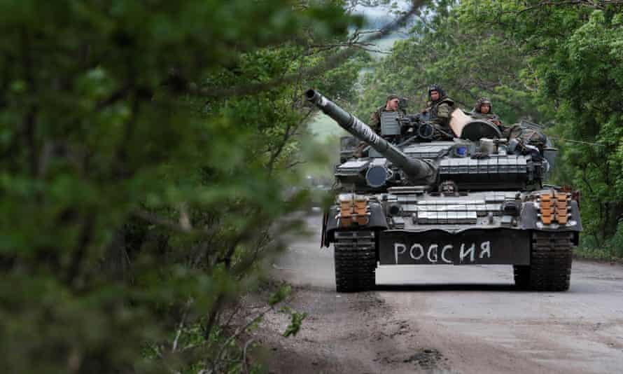 Service members of pro-Russian troops drive a tank in the Donetsk region of Ukraine. The writing on the tank reads: “Russia”.