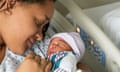 Black woman in a hospital bed holding her baby