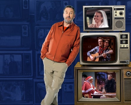 Lee Mack leans up against a stack of three televisions showing episodes of the sitcom Not Going Out