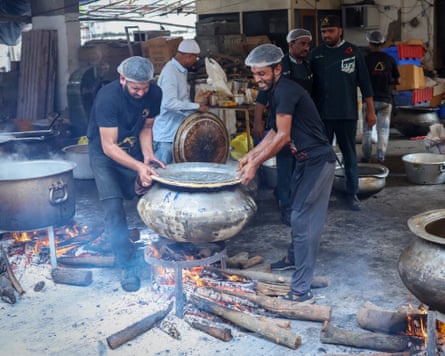 Chefs cook biryani in traditional cooking pots on wood fire at an open centralised kitchen