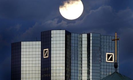 A rising full moon is seen over Deutsche Bank headquarters in Frankfurt.