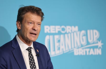 Richard Tice speaking at a Reform press event, the strapline ‘Reform cleaning up Britain’ on the wall behind him