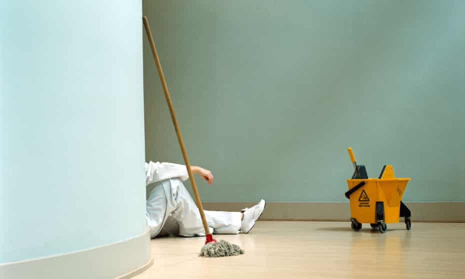 Cleaner sitting on floor next to mop and bucket