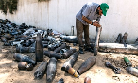 A bomb disposal official collects unexploded ordnance in and around Gaza city.