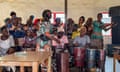 A group of Nigerian women singing together with two playing the drums