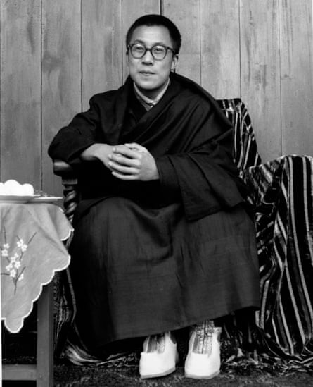 A black and white photo of the Dalai Lama as a young man, sitting on a chair