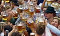 Large group of people holding up beer glasses