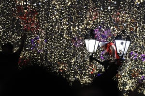 The celebrations continue across Moscow as a Russia fan climbs a streetlight a in Nikolskaya Street