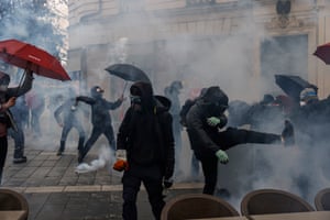 Protesters clashes with police officers as they stand in a cloud of teargas during a demonstration in Nantes, France