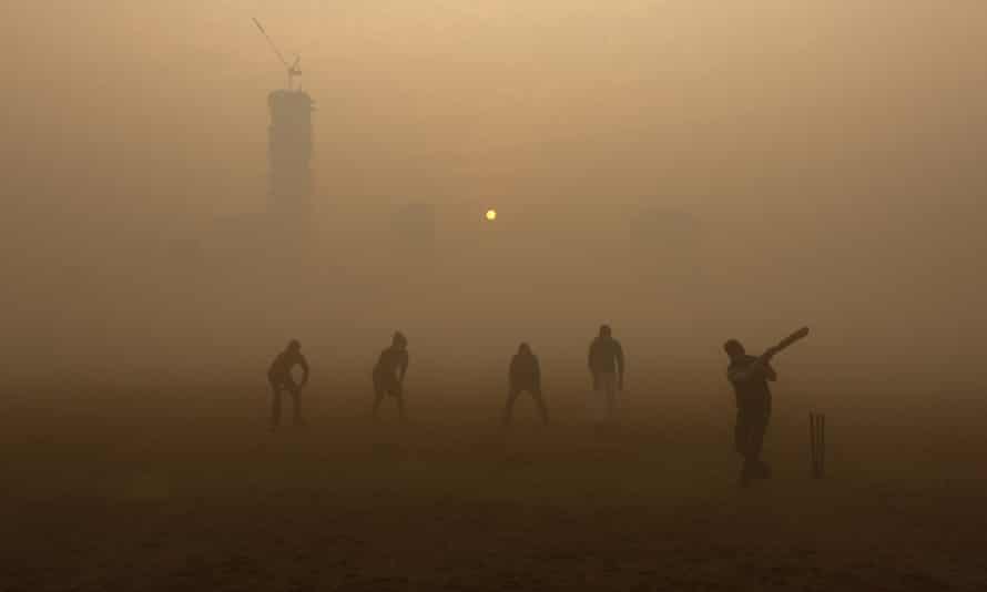 Boys play cricket in a public park amidst heavy fog on a cold winter morning in Kolkata, India
