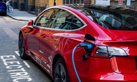 A Tesla Model 3 parked and charging on a London street