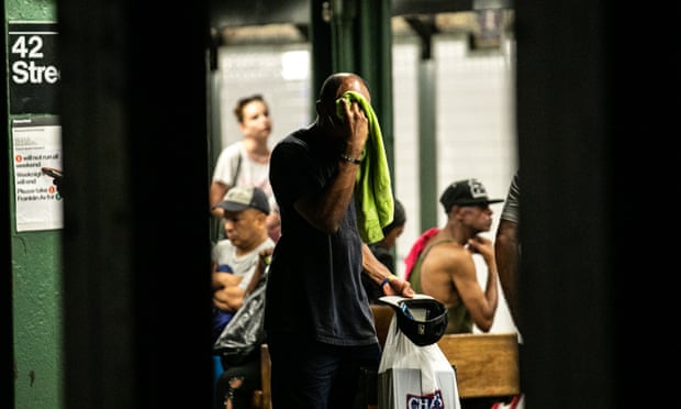 A man wipes his face with a towel while standing on subway platform in New York, US, on Saturday, July 20, 2019 amid forecasts of a heat wave