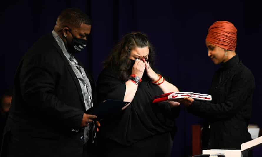 Aubrey y Katie Wright reciben una bandera presentada por Ilhan Omar durante el funeral.