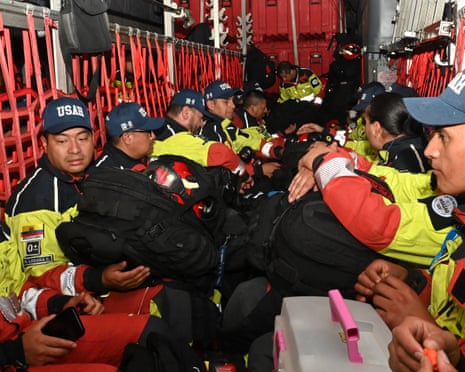 Firefighters sit close together on a plane.