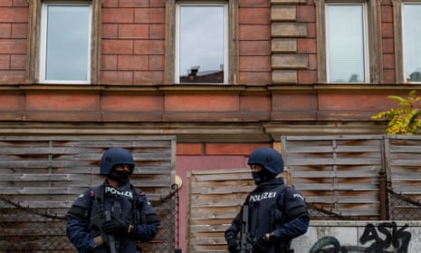 Police officers stand in front of a building in Linz, Austria, where a man was detained in connection with the Vienna shooting.