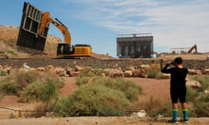 Workers build a wall in May along the US-Mexico border in Texas.
