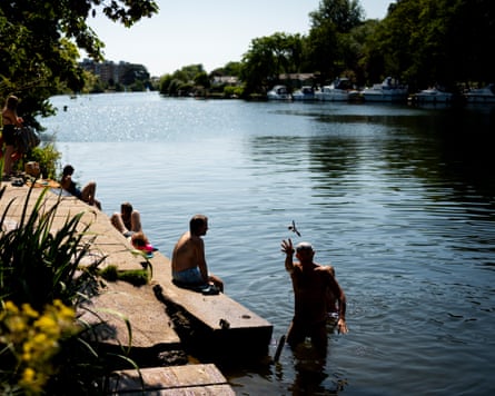 Swimmers wave and relax by the River Thames at Ham during a heatwave