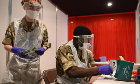 British soldiers process and record coronavirus tests inside Anfield Stadium in Liverpool.