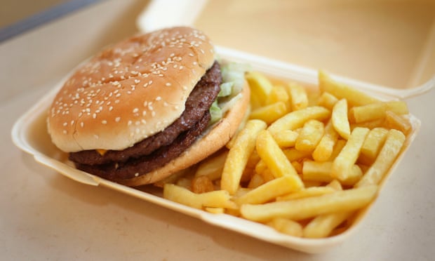 A burger and chips in a takeaway carton