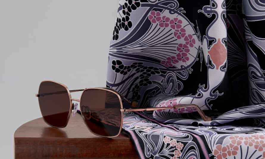 Sunglasses on a silk scar on top of a woodden table