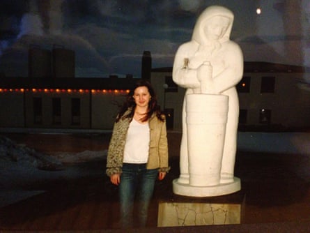 Hannah Kent as a teenager standing next to a statue of a woman churning butter