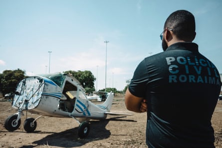 A Cidade da Polícia officer stood next to a small biplane