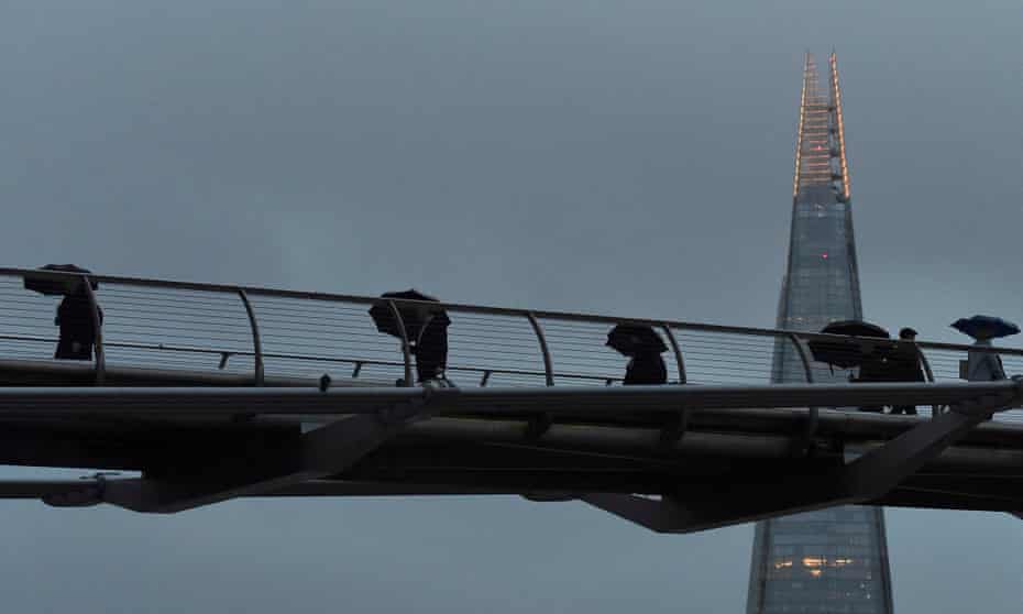 City workers cross the Millennium footbridge in London
