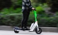 A man rides an e-scooter on a footpath.
