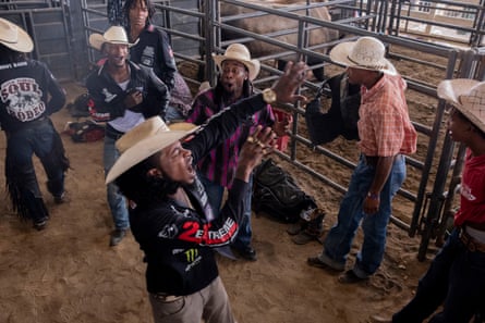 A group of men in cowboy hats joke with each other