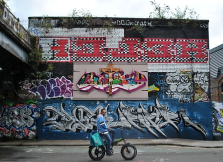 Graffiti and street art including Helch in red letters on a wall by a railway bridge.