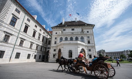 A horse-drawn carriage drives by the Hofburg palace in Vienna, part of the world heritage site in the city.