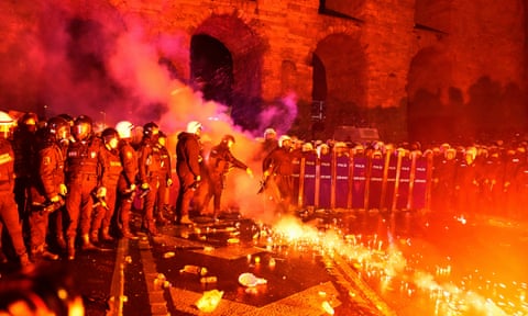 A police officer kicks a flare during a protest in Istanbul on 21 March 2025 against the arrest of the city’s mayor, Ekrem Imamoglu.
