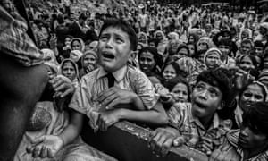 A Rohingya refugee boy cries as he climbs on a truck distributing aid for a local NGO near the Balukali refugee camp in Cox’s Bazar, Bangladesh.