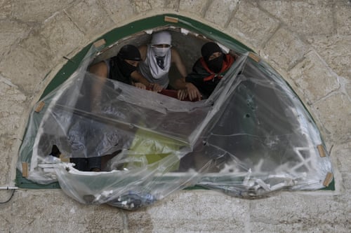 Masked Palestinians take position around the compound.