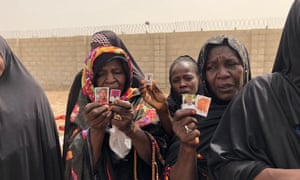 Women show photographs of relatives that have disappeared after being arrested by Nigeria’s military