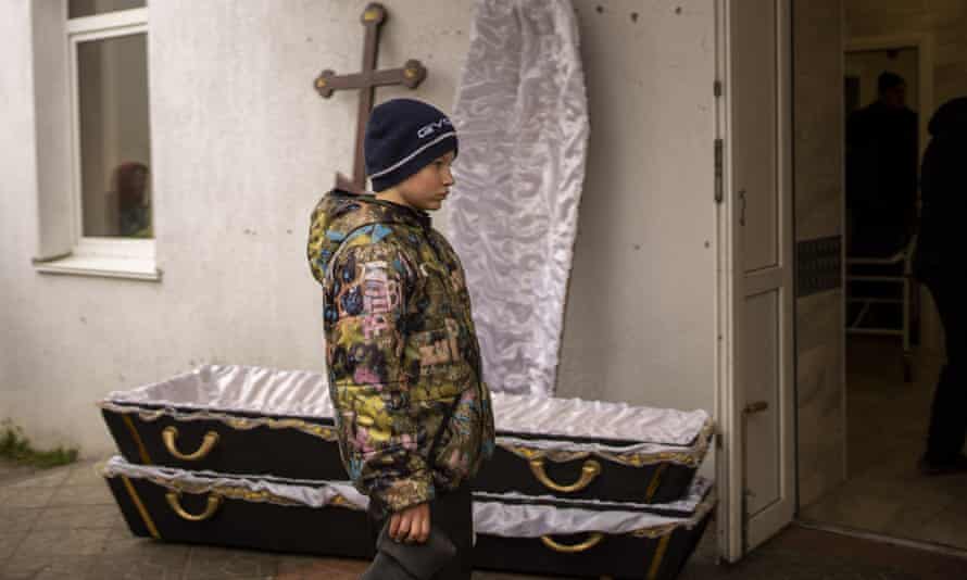 Vova, 10, looks as the body of his mother, Maryna, is taken from the morgue before her funeral in Bucha, on the outskirts of Kyiv, Ukraine, on Wednesday, April 20, 2022. Vova’s mother died while they sheltered in a cold basement for more than a month during the Russian military’s occupation.