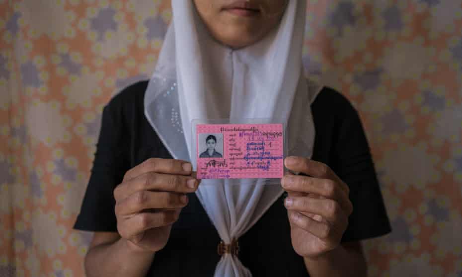 A young Muslim girls holds her identity card stating that her race is “Burmese Indian”. 