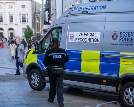 Essex Police officer beside live facial recognition van in Chelmsford