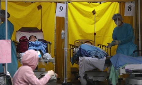 People who tested positive for Covid-19 at a waiting area outside a public hospital in Hong Kong, where the latest outbreak is stretching testing and health capacity.