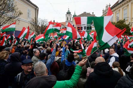 A crowd of people wave Hungarian flags
