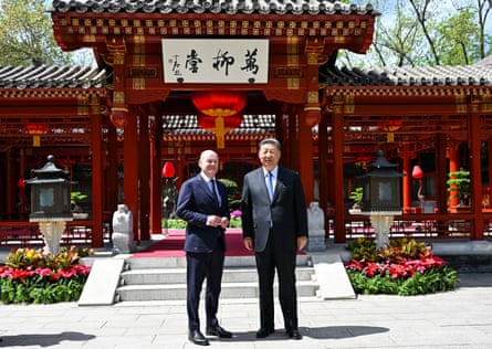 Two suited men pose for a photo in front of a traditional building in Beijing