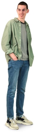 Maxim has close cropped hair, wears glasses with a green shirt, jeans and trainers.