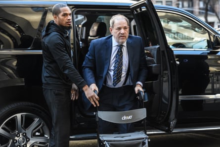 Weinstein leans on a walker as he exits from a black SUV.