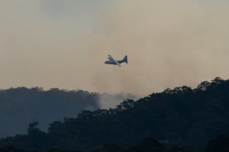 A waterbombing airplane flying over the fast-moving bushfire in the Koolewong area on 6 December, 2025.