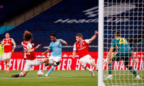 Arsenal’s David Luiz (left) jumps across to block a shot from Manchester City’s Raheem Sterling.