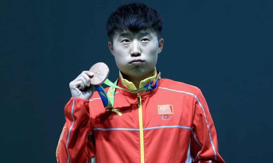 Disappointed bronze medalist Yuehong Li of China poses on the podium during the medal ceremony for the Men’s rapid fire pistol event.