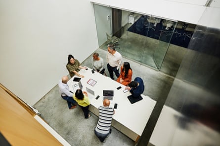 Wide, high-angle shot of a businesswoman leading a project meeting in office