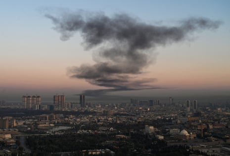 A plume of smoke rises near Erbil international airport in Iraq on Sunday. Loud explosions were heard near the airport, which hosts US-led coalition troops in Iraq's autonomous Kurdistan region. Follow the latest developments, live.