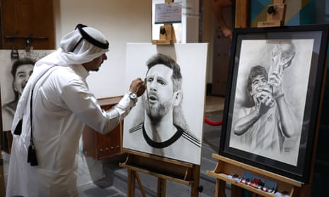 A local artist is seen with portraits of Lionel Messi and Diego Maradona in Doha.