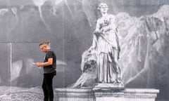 Caveman … a man stands next to a representation of Plato’s cave on the facade of the Opéra Garnier in Paris.